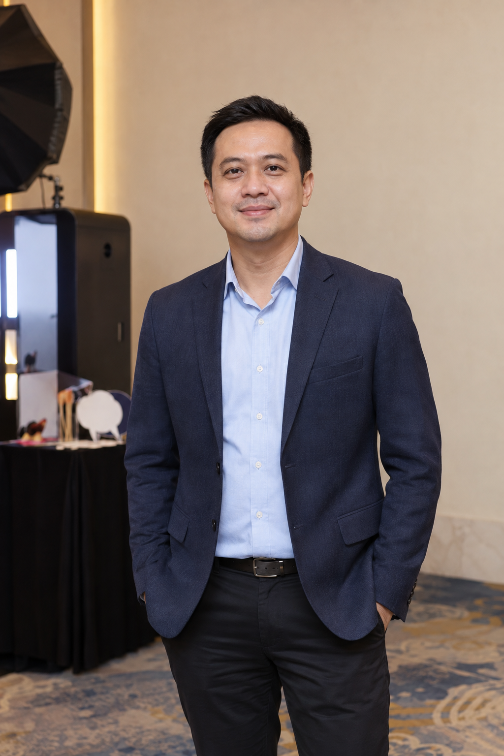 Sample male Business Summit guest in a navy blazer at a hotel photo booth
